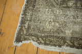 Distressed vintage Kula rug runner end, with light tattered ivory fringe and faded gray patterns.