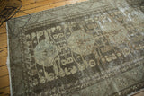 Distressed Kula rug detail featuring faded charcoal, gray, and beige geometric motifs.