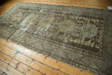 Distressed vintage Kula runner with geometric floral medallions, showcasing faded charcoal, gray, and ivory tones.