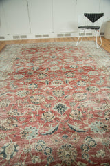 Distressed cherry red Kashan carpet showing worn pile, visible foundation, and floral motifs.