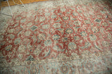 Distressed vintage Kashan carpet with worn cherry red field and intricate aqua blue border patterns.