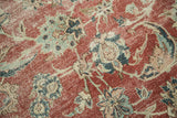 Distressed cherry red Kashan rug with worn pile, visible foundation, and faded Herati floral motifs.
