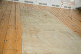 Faded beige and antique ivory medallion patterns on a distressed Oushak runner.
