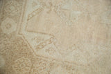 Distressed vintage Oushak rug pile with even wear, pale beige and ivory tones.
