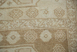 Distressed hand-knotted pile of a vintage Oushak runner, showing soft beige and bronze motifs.