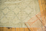 Distressed sea foam green Oushak rug featuring repeating panel pattern and bottom fringe.