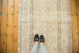 Distressed Oushak rug's right edge, showing allover cintimani patterns in muted beige and charcoal.