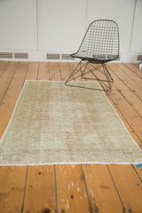 Distressed Oushak rug end, with mostly secure ivory fringe, foundation visible, and faded rose tones.
