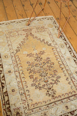 Vintage Oushak prayer rug's faded gold mehrab with delicate floral motifs.