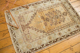 Bottom right corner of vintage Oushak rug, displaying fringe and patterned wine red border.