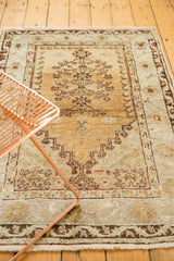 Vintage Oushak rug's lower border, fringe, and faded gold field with subtle motifs.