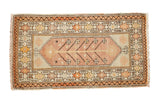 Blush and ivory vintage Oushak rug with central tree-of-life motif and starburst borders.