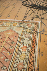 Geometric starburst border and vinery detail on a vintage Oushak rug in peach, ivory, saffron yellow.