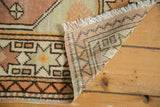 Vintage Oushak rug corner showing fringe, geometric pile, and hand-knotted foundation.