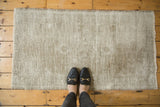 Distressed texture of a vintage Oushak rug, showing mostly foundation in beige and ivory.