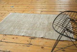 Distressed vintage Oushak rug texture showing mostly foundation and secured edge in pale sand.