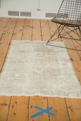 Distressed vintage Oushak rug's bottom edge with worn texture and visible foundation.