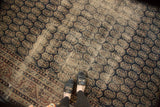 Heavily distressed vintage Sparta carpet, allover botehs with faded navy and bronze, underfoot view.