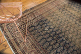 Distressed Sparta carpet displaying abrashed navy, pale bronze, madder root red boteh pattern.