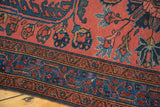 Vintage Lilihan rug detail: madder red field with sprawling florals, indigo and teal border.