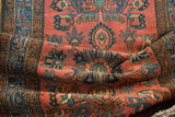 Close-up of folded vintage Lilihan runner, revealing madder red and indigo floral motifs.