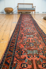 Hand-knotted vintage Lilihan runner with allover floral motifs, madder red field, and dark blue border.