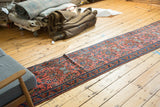 Long vintage Persian Lilihan runner rug with allover splayed floral design in madder red and deep blue.