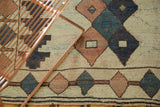 Textured pile of a distressed vintage Dosmealti rug, highlighting geometric ivory, navy, and rose diamonds.