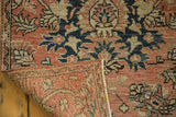 Distressed Hamadan rug corner revealing its hand-knotted foundation and soft floral pattern.
