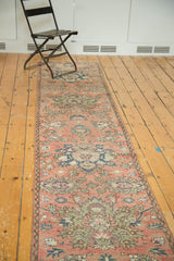 Distressed vintage Hamadan runner displaying blush serrated medallions, sky blue lotus, and winding vine detail.
