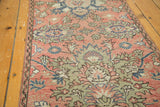 Distressed blush vintage Persian Hamadan rug showing floral vine details with pale blue and silver.