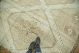 Distressed Turkish Oushak rug showing geometric diamond medallion in ivory and light coffee brown.