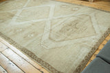 Distressed vintage Oushak with a partial diamond medallion and zig-zag border, in neutral tones.