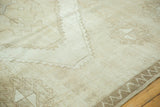 Close-up of the vintage Oushak rug, showcasing distressed texture and subtle neutral geometric patterns.