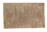 Distressed vintage Oushak rug featuring an allover trellis, starburst spandrels, and muted tones.