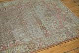Distressed vintage Oushak rug field showing blush, silver trellis and starburst corner.