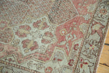 Decorative distressed texture on the vintage Oushak rug, featuring blush, ivory, and saffron hues.
