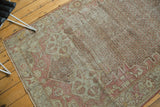 Vintage Distressed Oushak rug with blush starburst spandrels and worn trellis field.