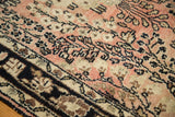 Vintage Lilihan rug with dusty rose and ivory floral sprays and a dark navy border.
