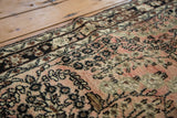 Detail of vintage Persian Lilihan rug's dusty rose floral spray motifs and border.