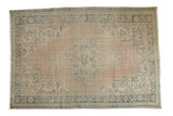 Distressed vintage Oushak carpet with apricot field, faded blue quatrefoil medallion, samovar details.