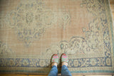Distressed Oushak carpet with faded apricot and pale blue ornate medallion patterns.