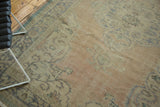 Vintage Distressed Oushak carpet's ornate scalloped border in apricot and pale blue.