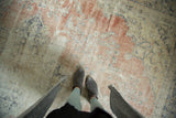 Textural distressed vintage Oushak rug showing blush, ivory, and navy colors with exposed foundation.