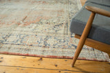 Distressed Oushak carpet texture featuring faded blush, royal blue, and ivory patterns with exposed foundation.