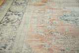 Hard distress and exposed foundation on the blush and ivory Oushak carpet.