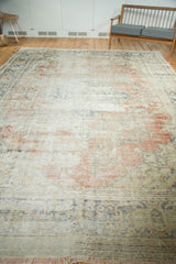Distressed Oushak carpet detail with exposed foundation, blush, navy, and ivory fringe.