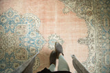 Textured blush and blue vintage Oushak rug, showing its artfully distressed finish.