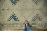 Vintage distressed Oushak runner showing an abrash ivory field with denim blue medallions.
