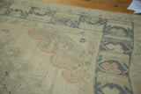 Distressed ivory pile on vintage Oushak runner with faded pink and blue motifs.